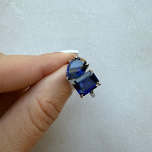 Toi et Moi ring with an emerald-cut Blue Sapphire and a pear-cut Blue Sapphire.