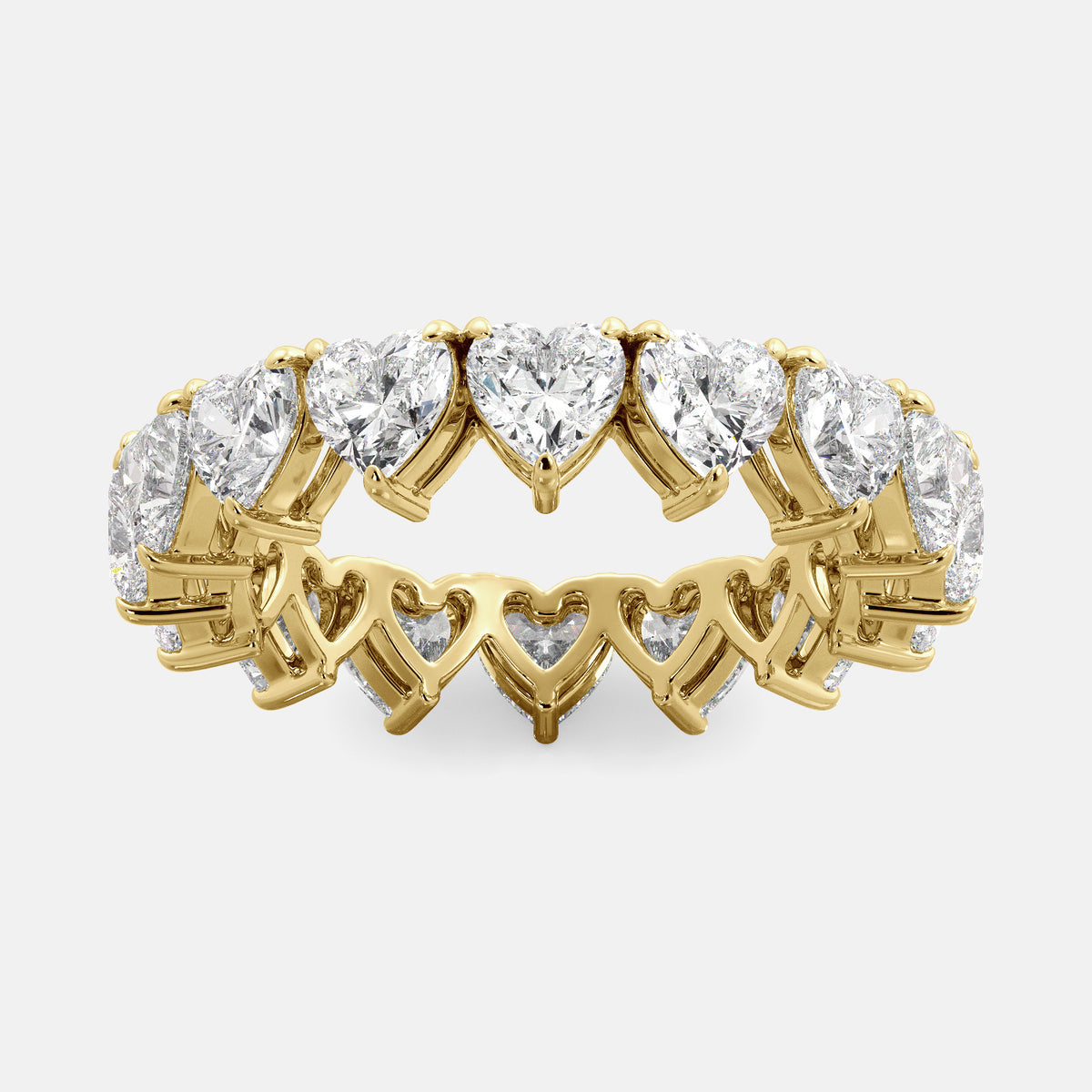 A close-up of a heart-shaped lab-grown diamond eternity wedding band in 14K yellow gold. The band is set with heart shape brilliant diamonds that sparkle and shine. The band is a beautiful and unique choice for a wedding band.
