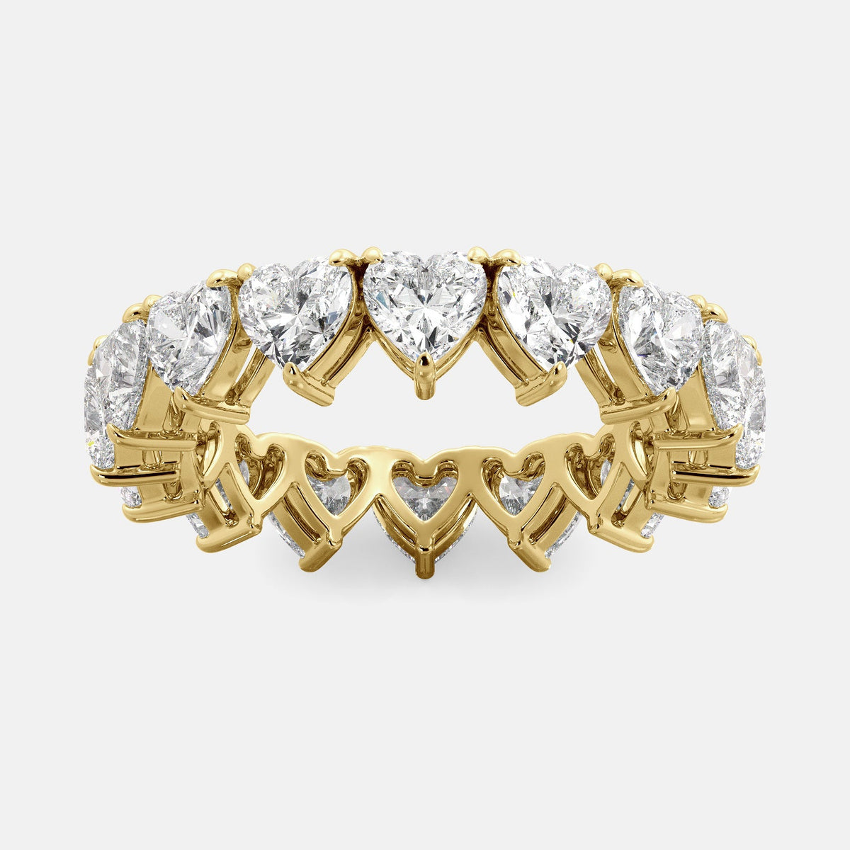 A close-up of a heart-shaped lab-grown diamond eternity wedding band in 14K yellow gold. The band is set with heart shape brilliant diamonds that sparkle and shine. The band is a beautiful and unique choice for a wedding band.