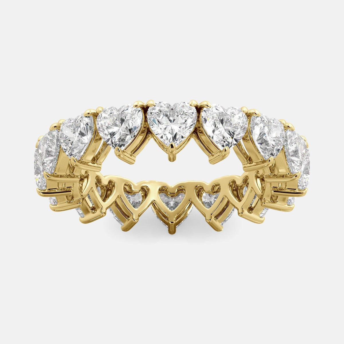 A close-up of a heart-shaped lab-grown diamond eternity wedding band in 14K yellow gold. The band is set with heart shape brilliant diamonds that sparkle and shine. The band is a beautiful and unique choice for a wedding band.