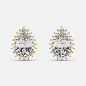 A pair of diamond emerald pear-cut halo stud earrings with gold accents on a white background.