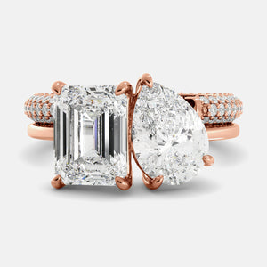 Rose gold ring with large diamond and smaller diamonds on a light gray background