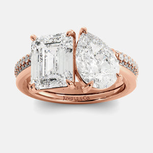 Rose gold ring with two diamond stones on a white background