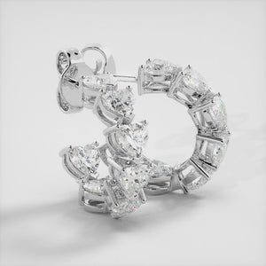 A pair of heart-shaped diamond hoop earrings in recycled white gold. The earrings are made of recycled white gold and have a simple, elegant design. The hoops are approximately 1 inch in diameter and are set with heart-shaped diamonds. The diamonds are sparkling and reflect light beautifully. The earrings are a perfect gift for a loved one or a special occasion.