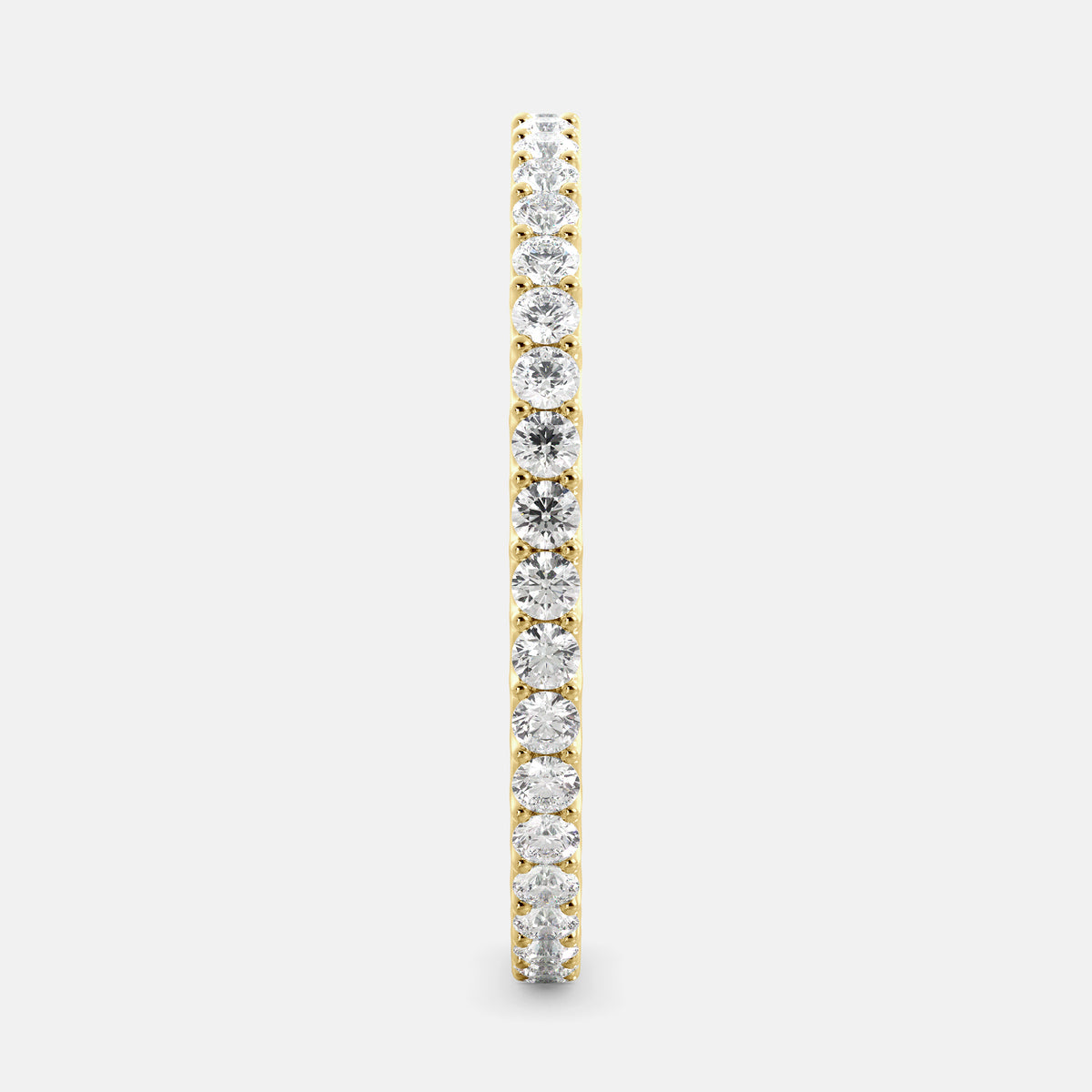 A close-up of a yellow gold eternity wedding band with a row of round diamonds. The band is a classic and timeless design that is perfect for any occasion. The diamonds sparkle and shine, adding a touch of glamour. The band is made of 14K yellow gold and features lab-grown diamonds that are conflict-free.