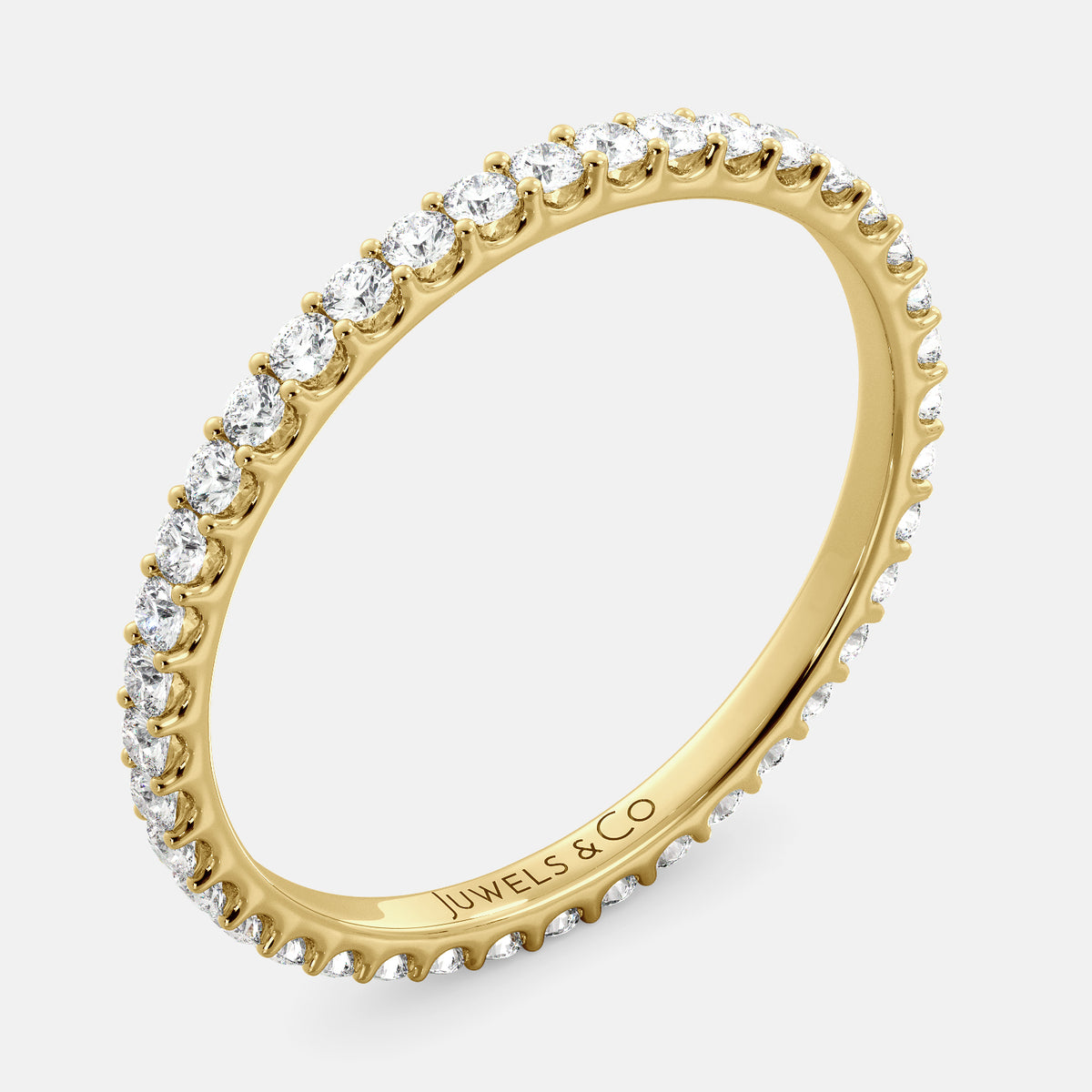 A close-up of a yellow gold eternity wedding band with a row of round diamonds. The band is a classic and timeless design that is perfect for any occasion. The diamonds sparkle and shine, adding a touch of glamour. The band is made of 14K yellow gold and features lab-grown diamonds that are conflict-free.