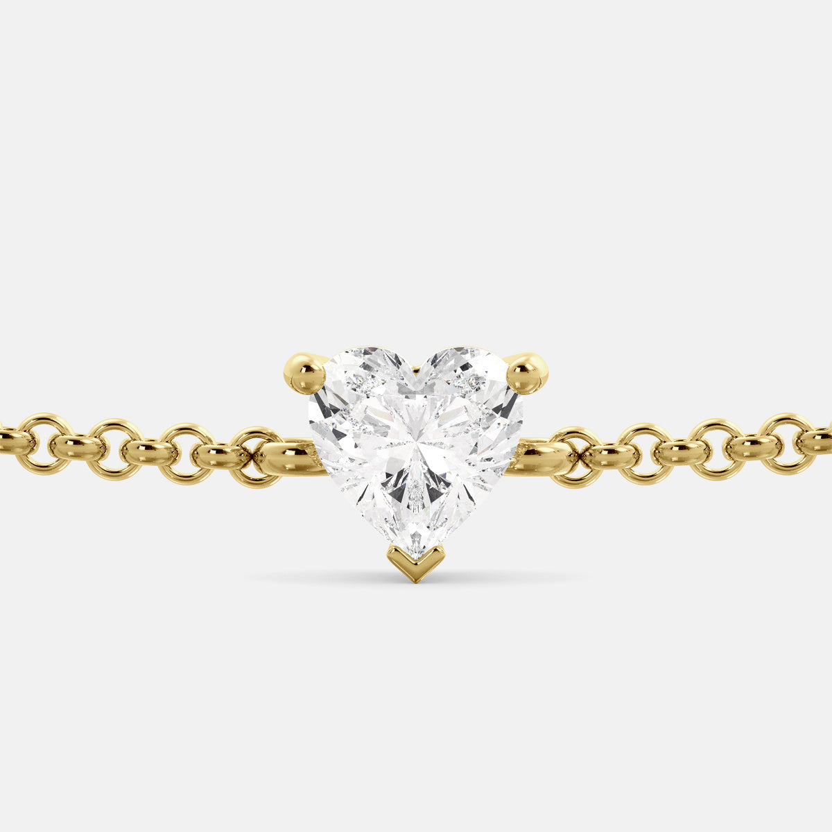 A close-up of a heart-shaped diamond bracelet in recycled yellow gold. The bracelet is set with a single, large diamond in the center of a heart-shaped pendant. The bracelet is made of recycled yellow gold and has a simple, elegant design. The diamond is sparkling and reflects light beautifully. The bracelet is a perfect gift for a loved one or a special occasion.