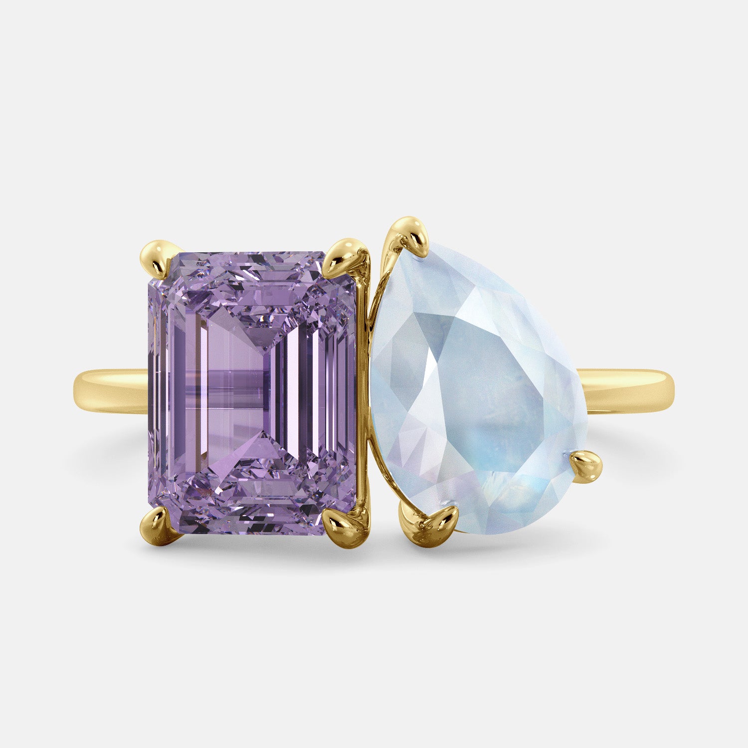 A toi et moi ring with an emerald-cut amethyst and a pear-cut gemstone. The emerald-cut is set on the left of the ring, and the pear-cut gemstone is set on the right. The ring is made of recycled yellow gold and has a simple, elegant design. The pear-cut gemstone can be customized. **Here are some additional details about the image:** * The emerald-cut amethyst is a birthstone for February. * The pear-cut gemstone can be customized to any stone of your choice.