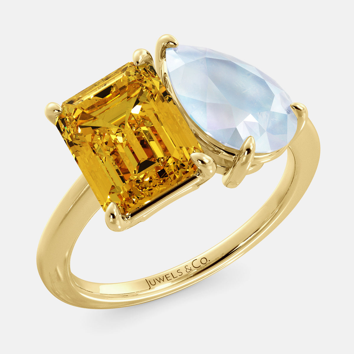 A toi et moi ring with an emerald-cut Citrin and pear-cut gemstone. The emerald-cut morganite is set on the left of the ring, and the pear-cut gemstone is set on the right. The ring is made of recycled yellow gold and has a simple, elegant design. The pear-cut gemstone can be customized. **Here are some additional details about the image:** * The emerald-cut white Citrin is a birthstone for November. * The pear-cut gemstone can be customized to any stone of your choice.