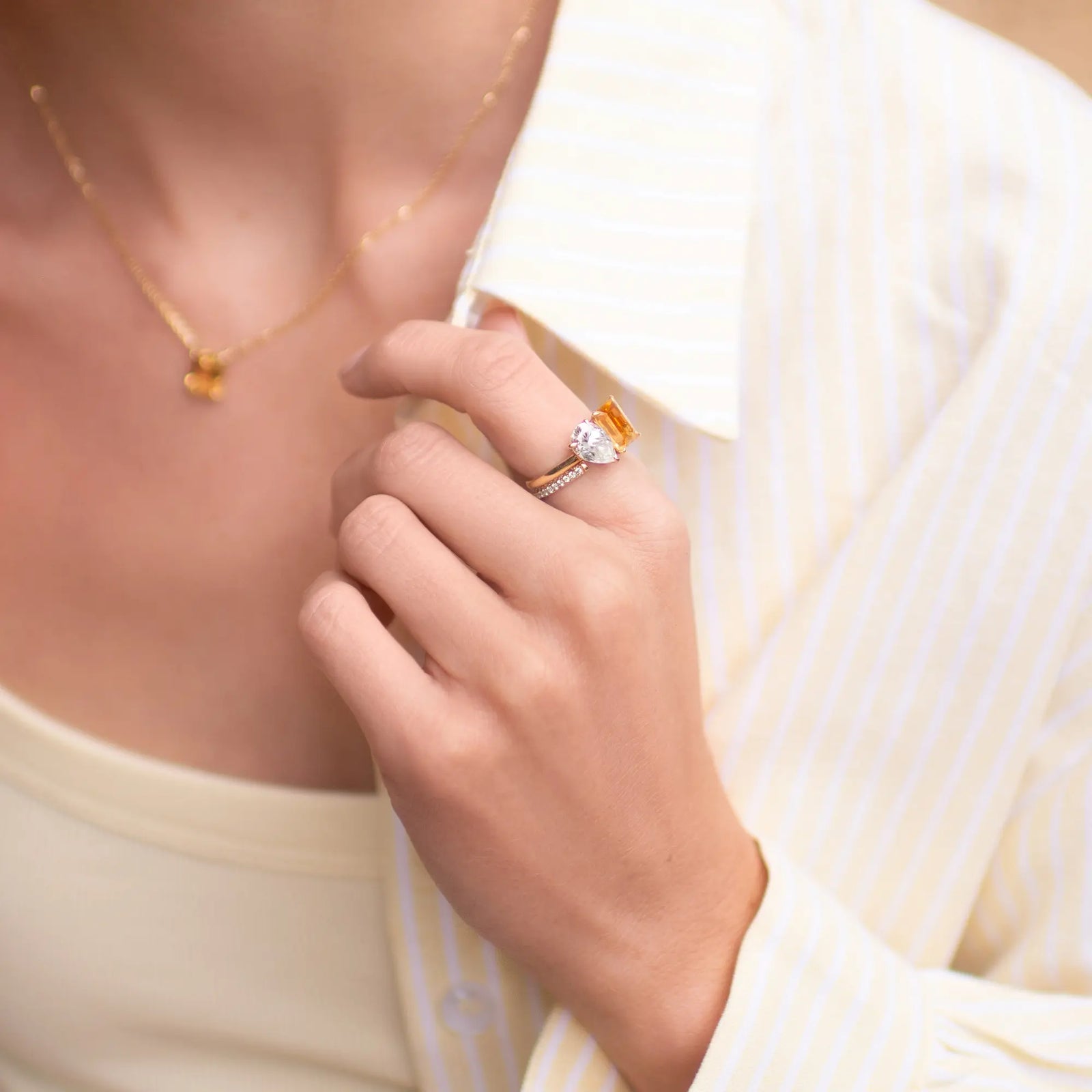Close-up of a hand wearing a ring with a yellow background