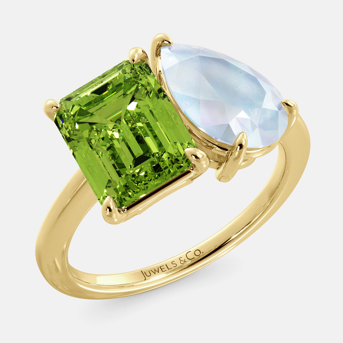 A toi et moi ring with an emerald-cut Green Peridot and a pear-cut gemstone. The emerald-cut morganite is set on the left of the ring, and the pear-cut gemstone is set on the right. The ring is made of recycled yellow gold and has a simple, elegant design. The pear-cut gemstone can be customized. **Here are some additional details about the image:** * The emerald-cut white Green Peridot is a birthstone for August. * The pear-cut gemstone can be customized to any stone of your choice.