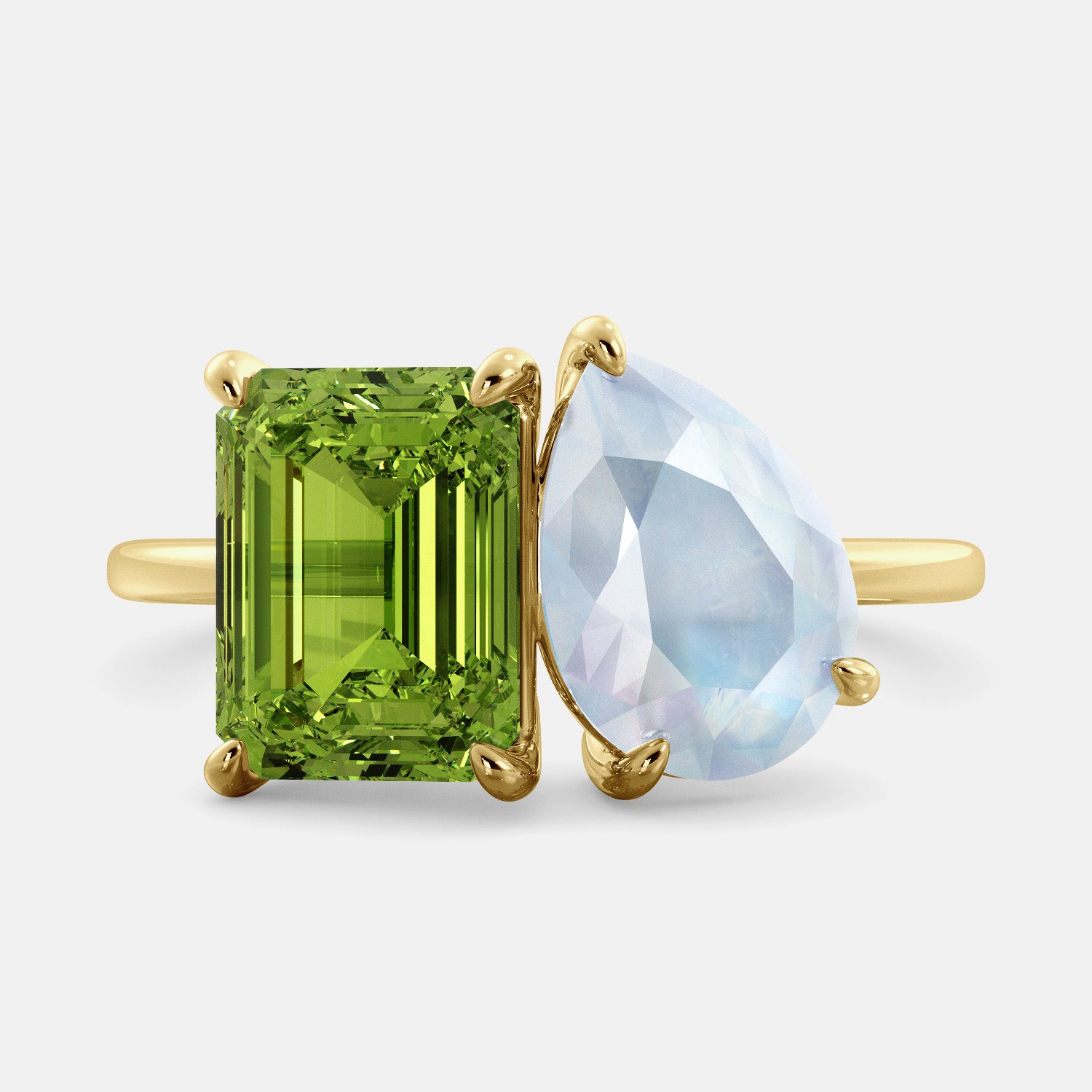 A toi et moi ring with an emerald-cut Green Peridot and a pear-cut gemstone. The emerald-cut morganite is set on the left of the ring, and the pear-cut gemstone is set on the right. The ring is made of recycled yellow gold and has a simple, elegant design. The pear-cut gemstone can be customized. **Here are some additional details about the image:** * The emerald-cut white Green Peridot is a birthstone for August. * The pear-cut gemstone can be customized to any stone of your choice.