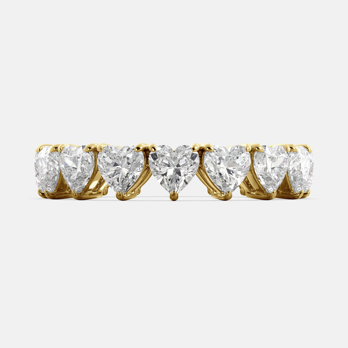 A close-up of a heart-shaped lab-grown diamond eternity wedding band in 14K yellow gold. The band is set with heart shape brilliant diamonds that sparkle and shine. The band is a beautiful and unique choice for a wedding band.