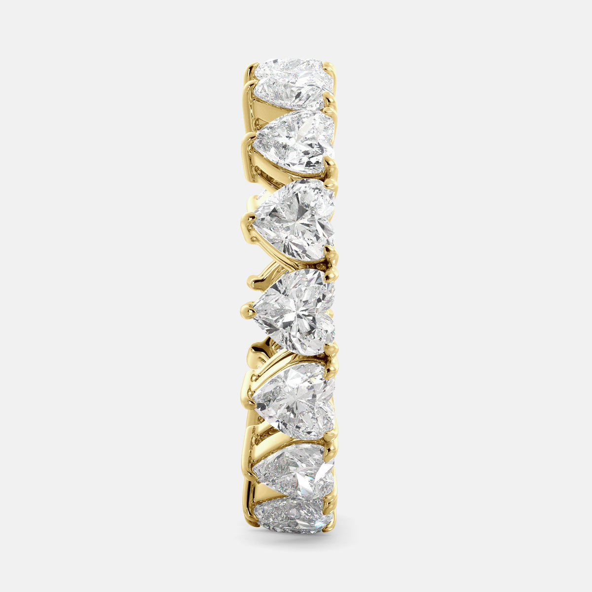 A close-up of a heart-shaped lab-grown diamond eternity wedding band in 14K yellow gold. The band is set with heart shape brilliant diamonds that sparkle and shine. The band is a beautiful and unique choice for a wedding band.