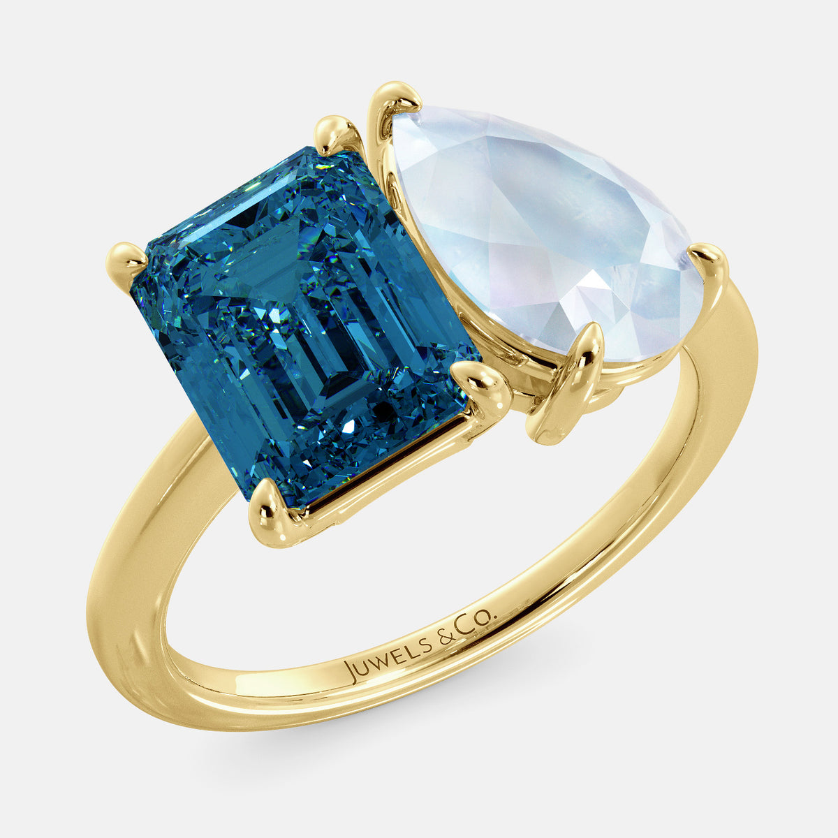 A toi et moi ring with a London blue topaz stone in emerald cut and a pear-shaped stone. The London blue topaz is a bright blue color and the pear-shaped stone can be customized to represent the birth month stone of the wearer or a loved one. The ring is made of 14k yellow gold and available in all sizes. This ring is a perfect gift for any occasion, and it can be customized to make it truly unique.