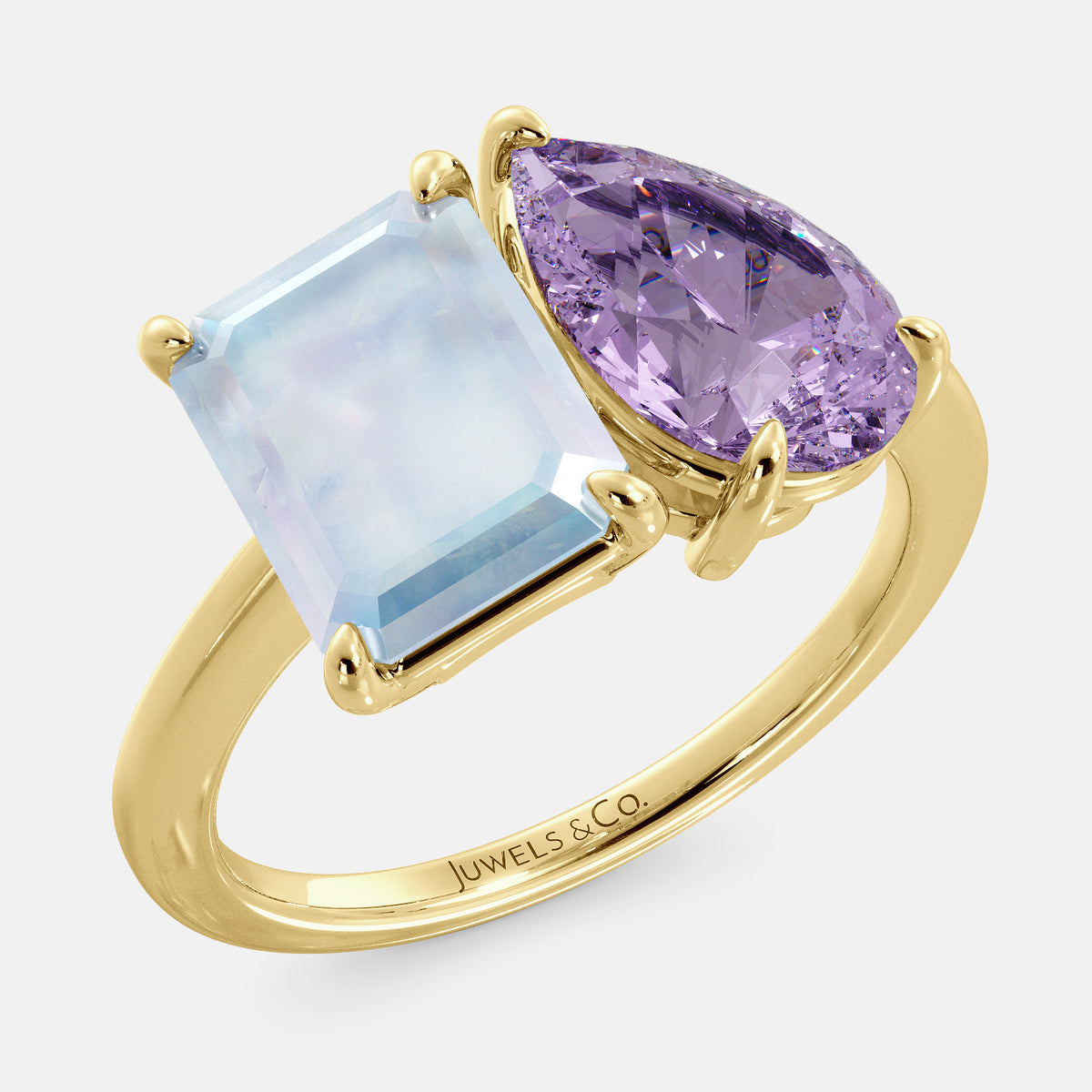 A toi et moi ring with an emerald-cut moonstone and a pear-cut gemstone. The emerald-cut is set on the left of the ring, and the pear-cut gemstone is set on the right. The ring is made of recycled yellow gold and has a simple, elegant design. The pear-cut gemstone can be customized. **Here are some additional details about the image:** * The emerald-cut white moonstone is a birthstone for June. * The pear-cut gemstone can be customized to any stone of your choice.