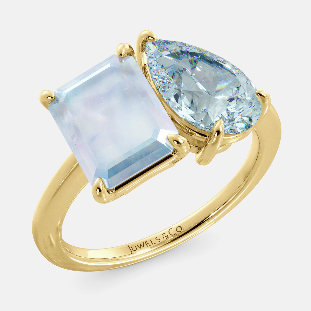A toi et moi ring with an emerald-cut moonstone and a pear-cut gemstone. The emerald-cut morganite is set on the left of the ring, and the pear-cut gemstone is set on the right. The ring is made of recycled yellow gold and has a simple, elegant design. The pear-cut gemstone can be customized. **Here are some additional details about the image:** * The emerald-cut white moonstone is a birthstone for June. * The pear-cut gemstone can be customized to any stone of your choice.