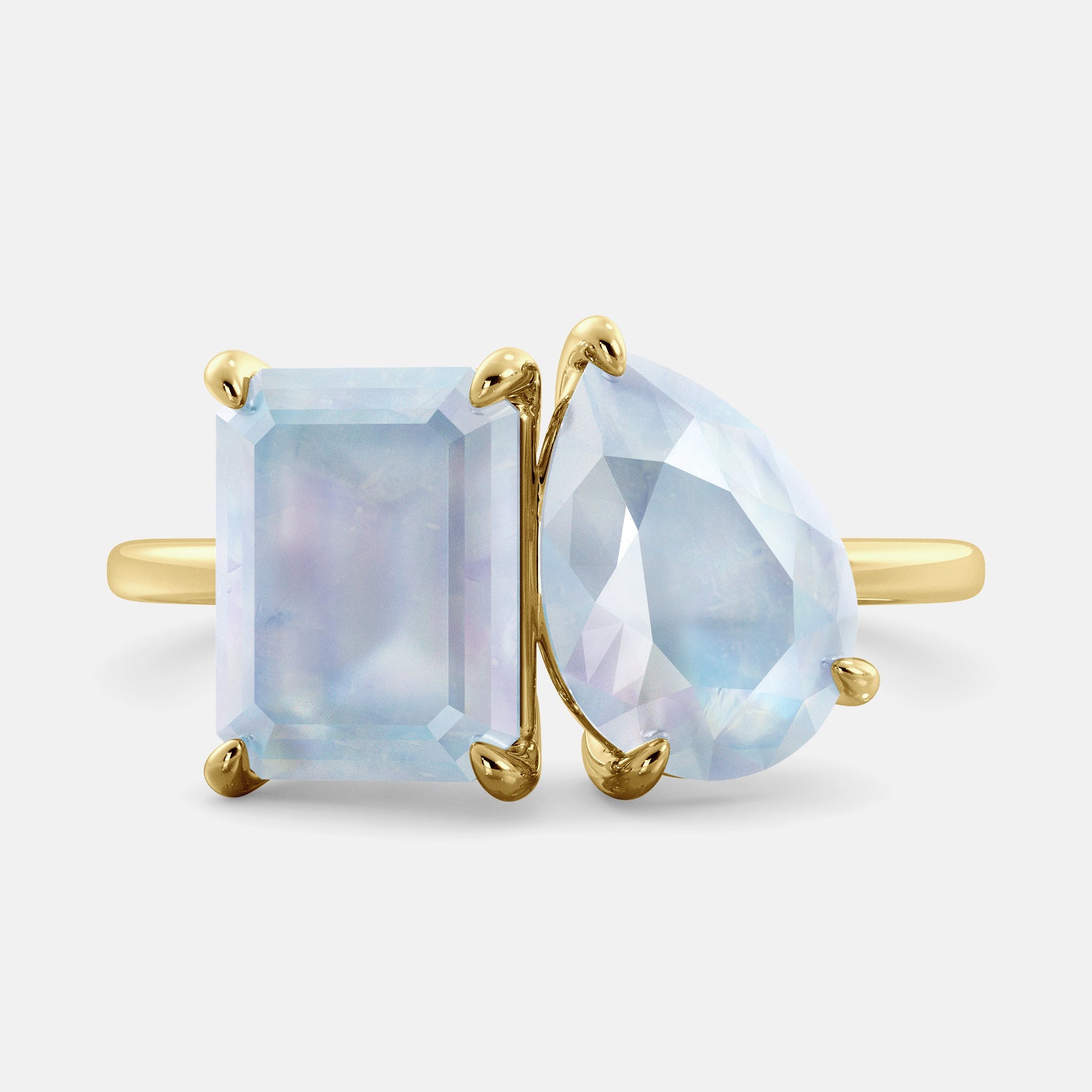 A toi et moi ring with an emerald-cut moonstone and a pear-cut gemstone. The emerald-cut morganite is set on the left of the ring, and the pear-cut gemstone is set on the right. The ring is made of recycled yellow gold and has a simple, elegant design. The pear-cut gemstone can be customized. **Here are some additional details about the image:** * The emerald-cut white moonstone is a birthstone for June. * The pear-cut gemstone can be customized to any stone of your choice.
