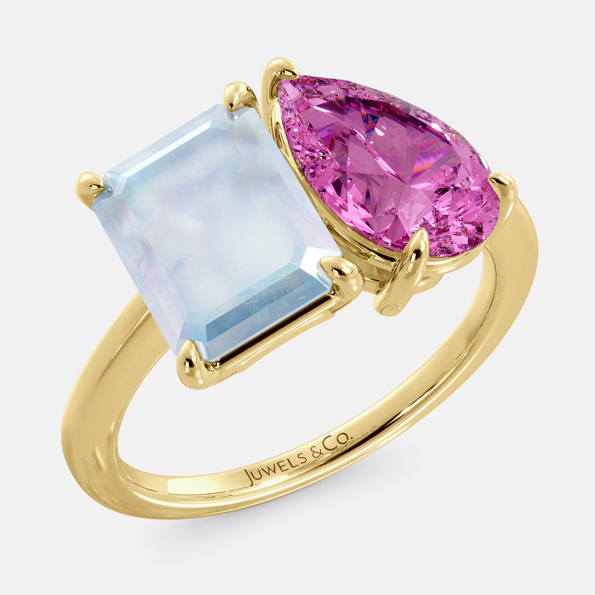 A toi et moi ring with an emerald-cut moonstone and a pear-cut gemstone. The emerald-cut morganite is set on the left of the ring, and the pear-cut gemstone is set on the right. The ring is made of recycled yellow gold and has a simple, elegant design. The pear-cut gemstone can be customized. **Here are some additional details about the image:** * The emerald-cut white moonstone is a birthstone for June. * The pear-cut gemstone can be customized to any stone of your choice.