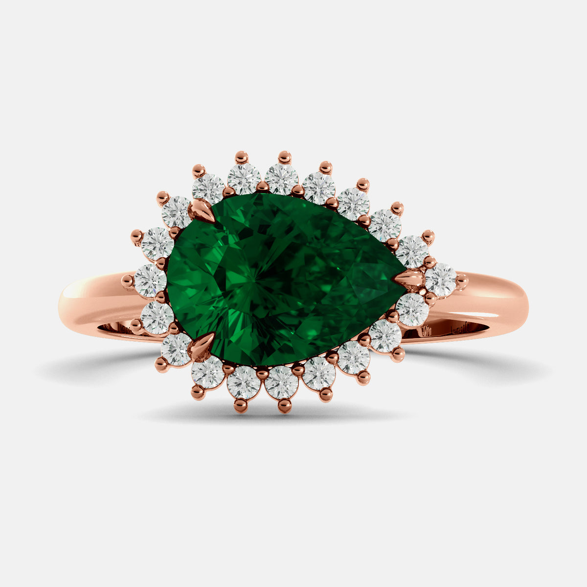 Rose gold ring with a large green gemstone and smaller diamonds on a light gray background