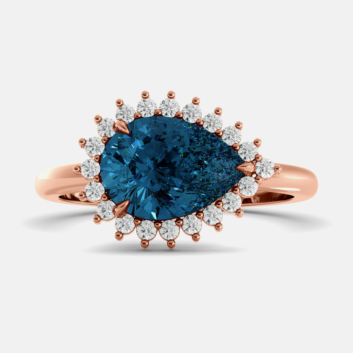 Rose gold ring with a blue gemstone and smaller diamonds on a light gray background