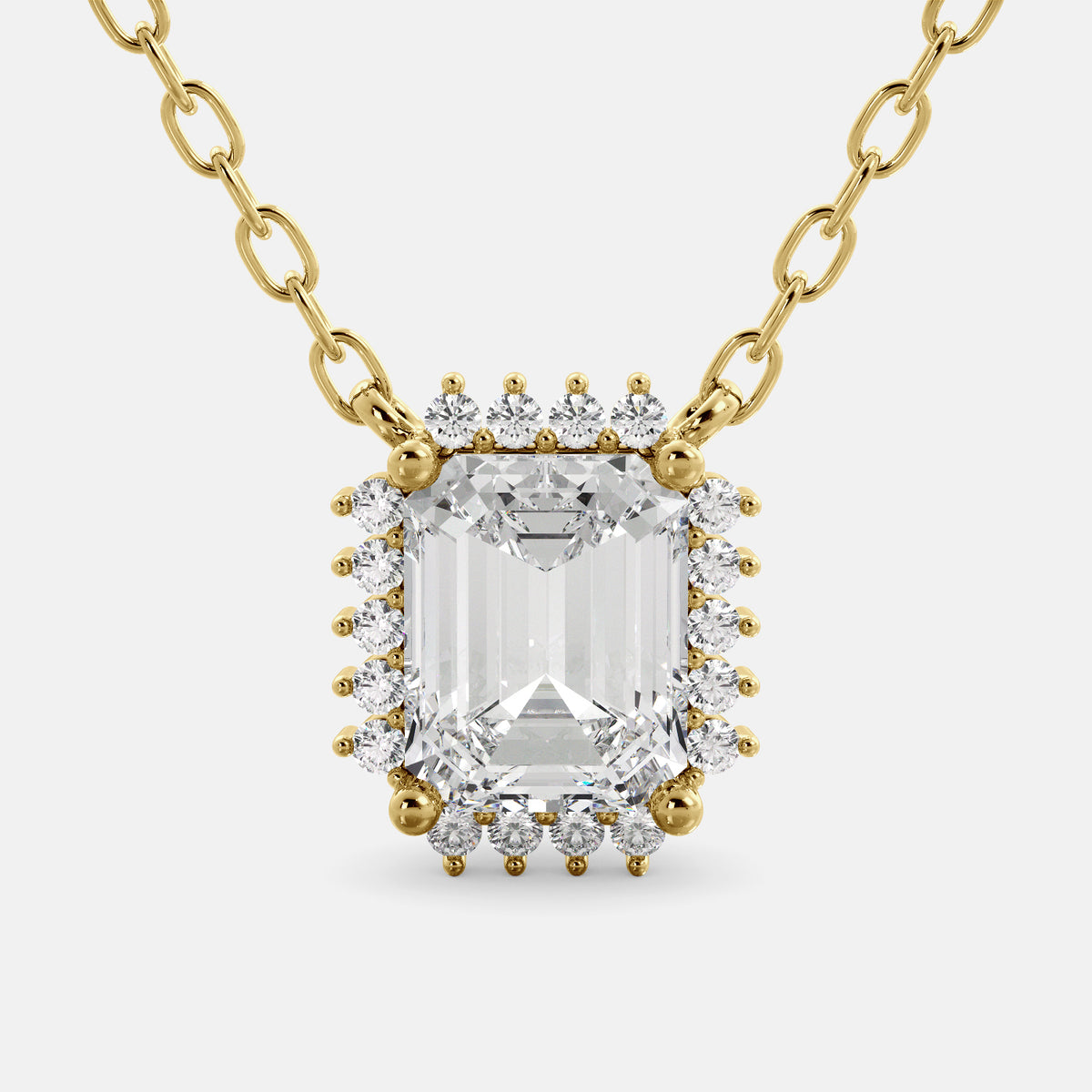 An emerald-cut garnet necklace with a halo of smaller diamonds set in a gold chain.