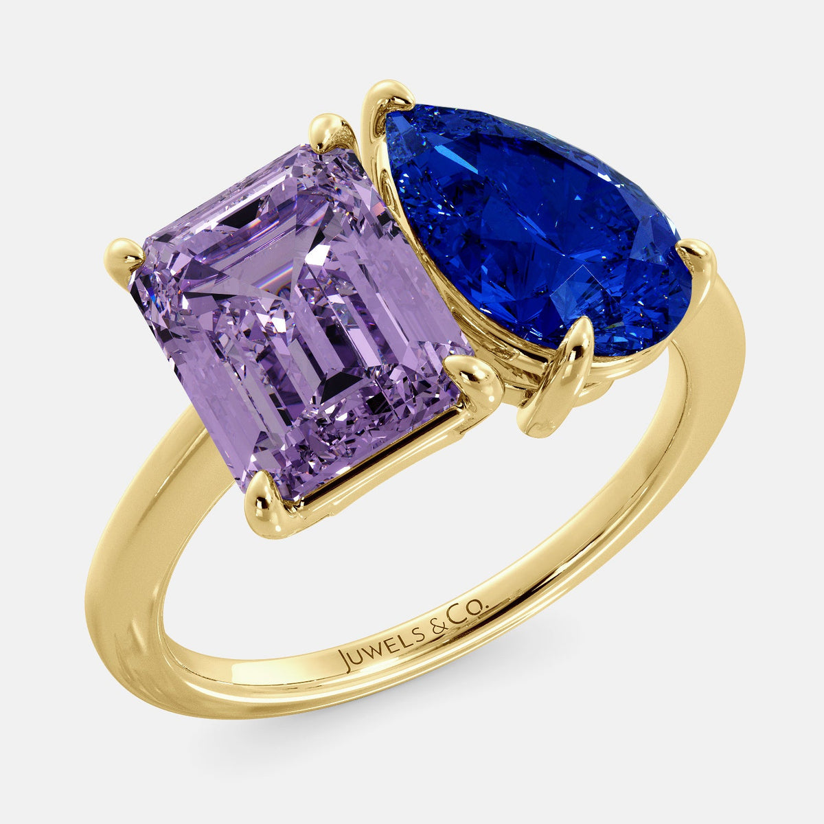 A toi et moi ring with an emerald-cut amethyst and a pear-cut gemstone. The emerald-cut morganite is set on the left of the ring, and the pear-cut gemstone is set on the right. The ring is made of recycled yellow gold and has a simple, elegant design. The pear-cut gemstone can be customized. **Here are some additional details about the image:** * The emerald-cut amethyst is a birthstone for February. * The pear-cut gemstone can be customized to any stone of your choice.