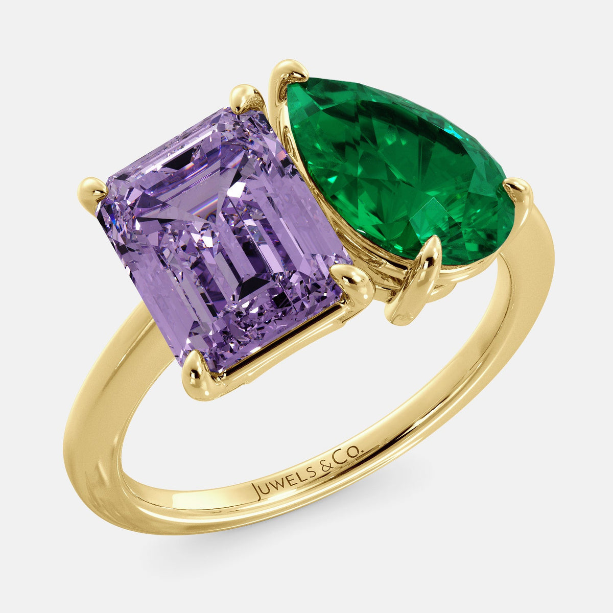 A toi et moi ring with an emerald-cut amethyst and a pear-cut gemstone. The emerald-cut morganite is set on the left of the ring, and the pear-cut gemstone is set on the right. The ring is made of recycled yellow gold and has a simple, elegant design. The pear-cut gemstone can be customized. **Here are some additional details about the image:** * The emerald-cut amethyst is a birthstone for February. * The pear-cut gemstone can be customized to any stone of your choice.