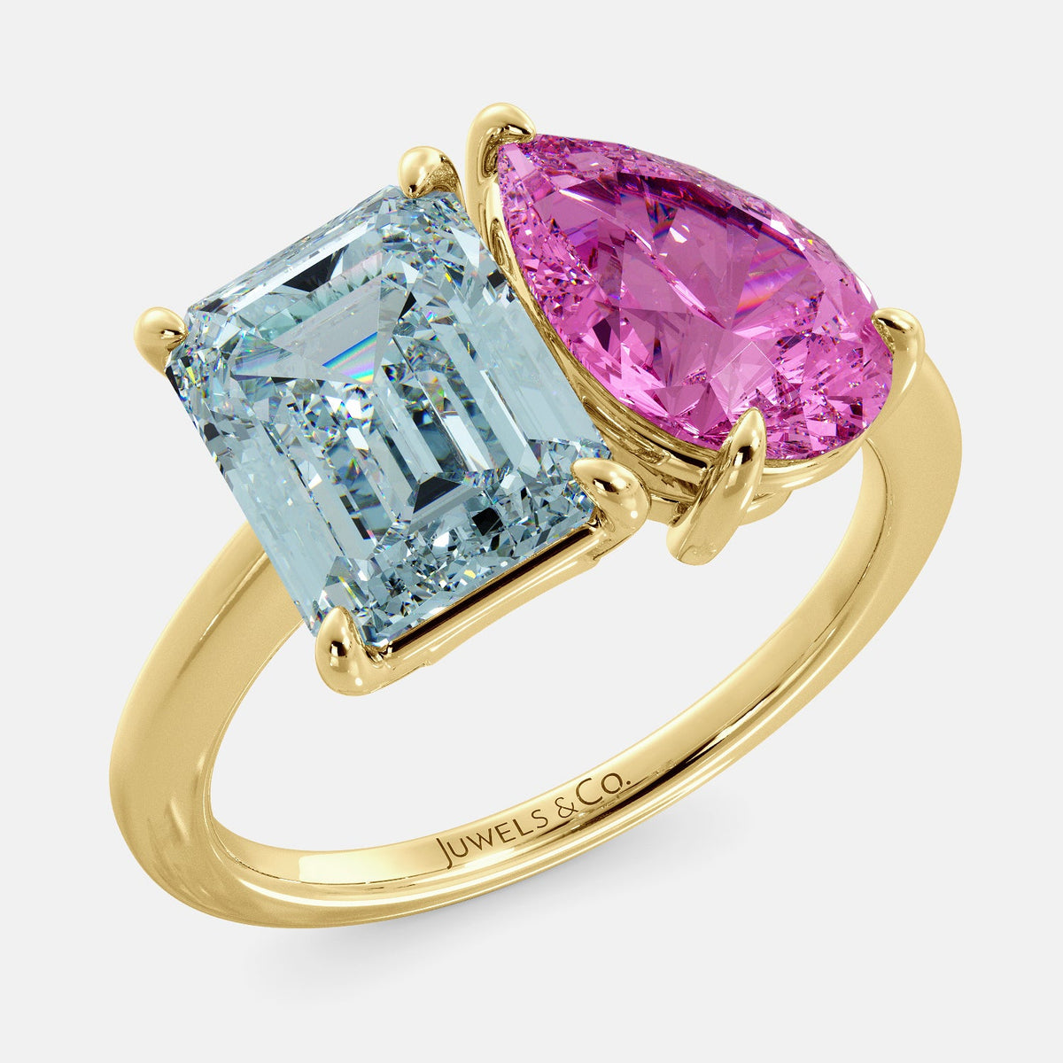 A toi et moi ring with an emerald-cut aquamarine and a pear-cut gemstone. The emerald-cut morganite is set on the left of the ring, and the pear-cut gemstone is set on the right. The ring is made of recycled yellow gold and has a simple, elegant design. The pear-cut gemstone can be customized. **Here are some additional details about the image:** * The emerald-cut aquamarine is a birthstone for March. * The pear-cut gemstone can be customized to any stone of your choice.