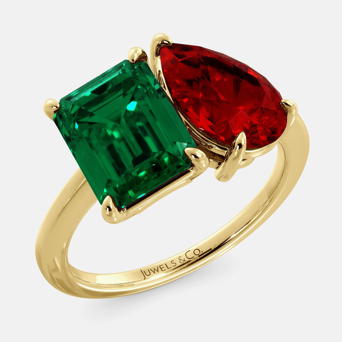 A toi et moi ring with an emerald-cut emerald and a pear-cut gemstone. The emerald-cut morganite is set on the left of the ring, and the pear-cut gemstone is set on the right. The ring is made of recycled yellow gold and has a simple, elegant design. The pear-cut gemstone can be customized. **Here are some additional details about the image:** * The emerald-cut white emerald is a birthstone for May. * The pear-cut gemstone can be customized to any stone of your choice.