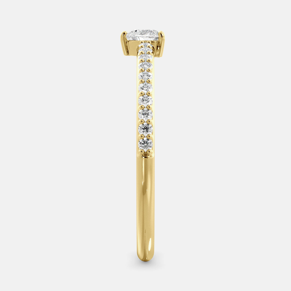 A close-up of a heart-shaped diamond ring with side stones in recycled yellow gold. The ring is set with a single, large diamond in the center of a heart-shaped setting. The ring is made of recycled yellow gold and has a simple, elegant design. The diamond is sparkling and reflects light beautifully. The side stones are smaller diamonds that are set in the band of the ring. The ring is a perfect gift for a loved one or a special occasion.