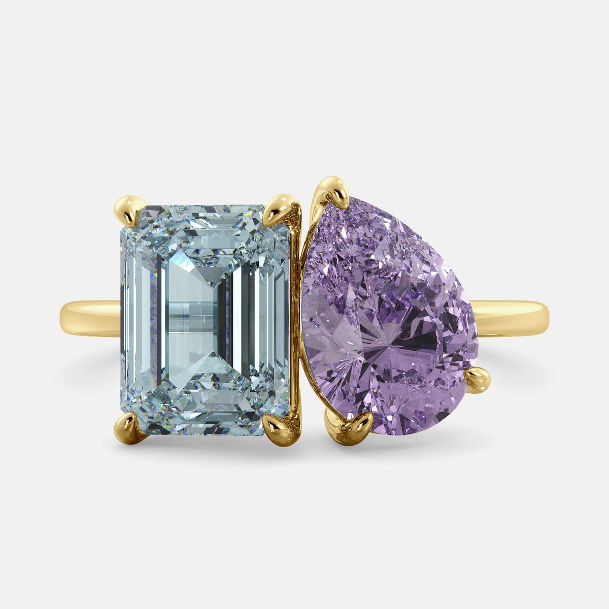 A toi et moi ring with an emerald cut aquamarine and a pear cut amethyst. The ring is set in a 14k yellow gold band and is available in all sizes. Aquamarine is a blue gemstone that is said to promote spiritual growth and strengthen self-confidence. Amethyst is a purple gemstone that is said to promote peace, love, and harmony. The toi et moi ring is a beautiful and unique way to show your love and commitment to someone special.