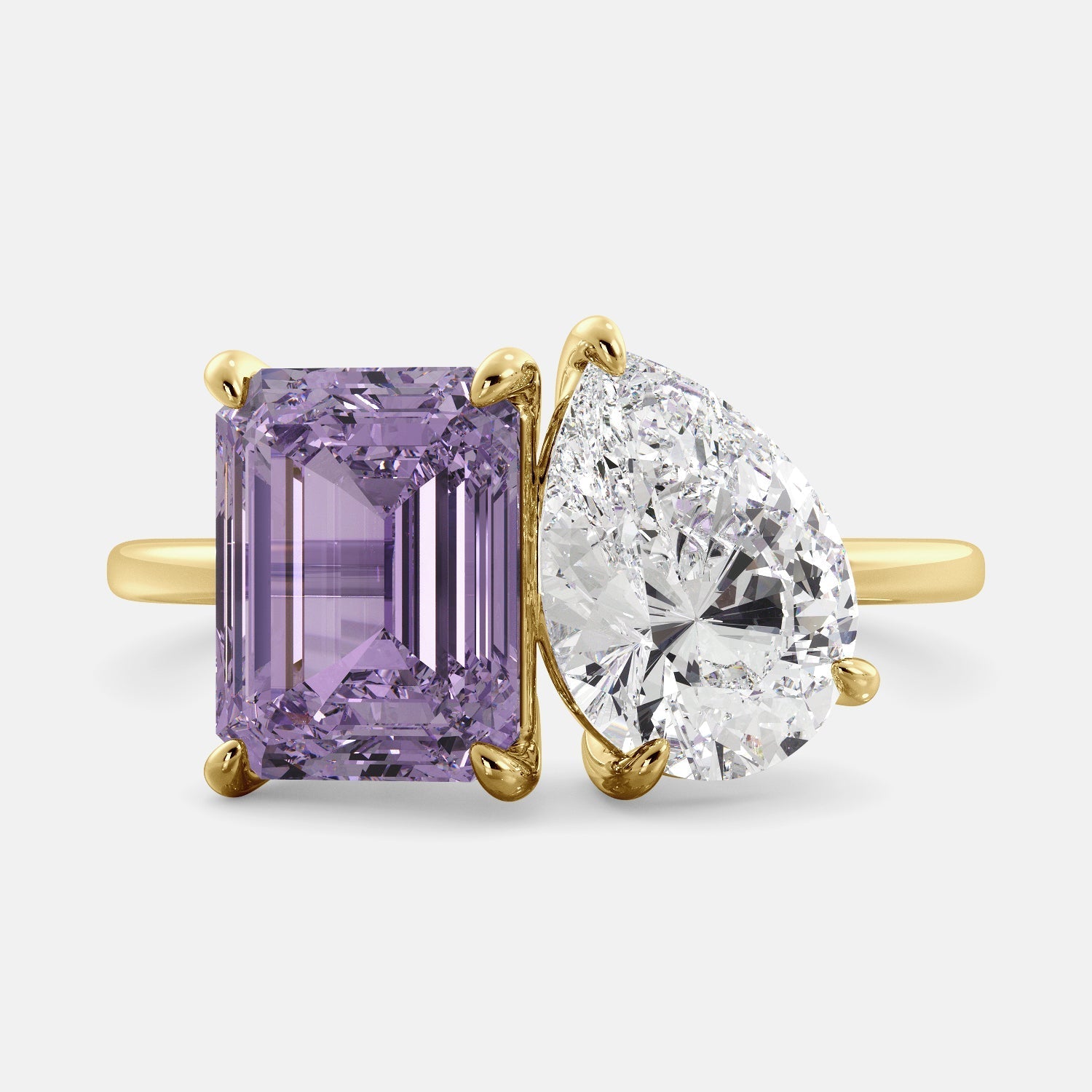 This image shows a toi et moi ring with a pear-shaped white topaz and an emerald-cut amethyst. The ring is set in a 14k yellow gold band and is available in all sizes. The amethyst is a purple gemstone that is said to promote peace, love, and harmony. The white topaz is a clear, colorless stone that is said to promote creativity, imagination, and self-expression. The toi et moi ring is a beautiful and unique way to show your love and commitment to someone special.