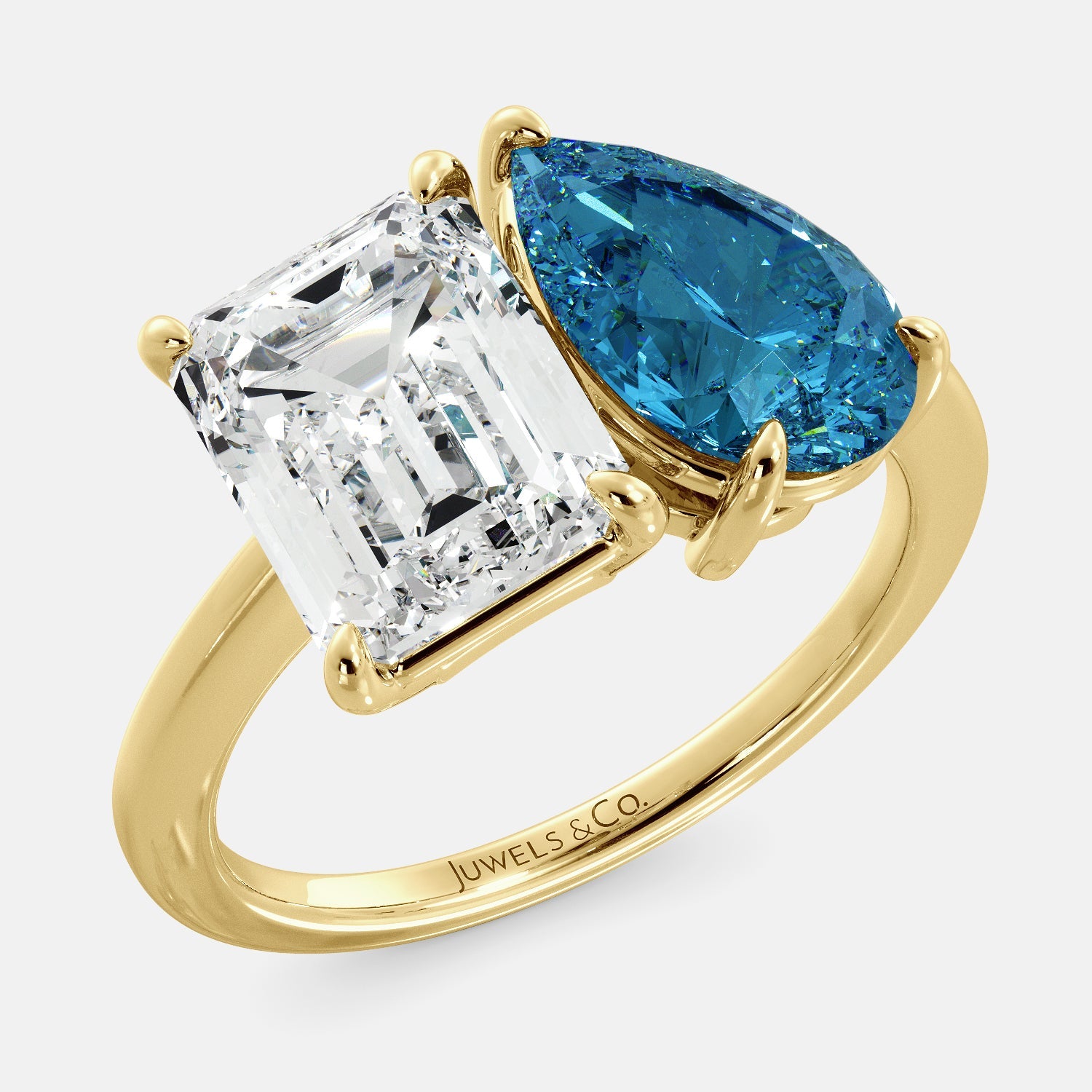  A toi et moi ring with a white topaz in an emerald cut shape and a london blue topaz pear shape gem. The ring is made of 14k yellow gold and is set on a dainty band. The white topaz is set in the center of the ring and is surrounded by the london blue topaz. The ring is sparkling in the light and is a beautiful and meaningful piece of jewelry.