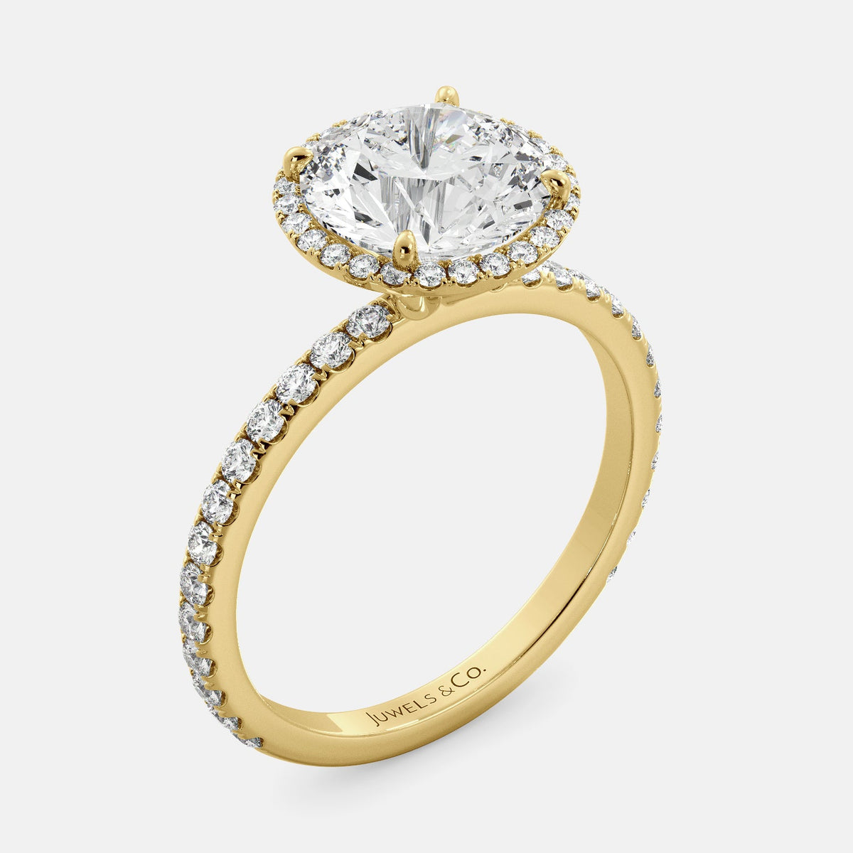This image shows a beautiful round halo lab-diamond ring with pavé on a yellow gold band. The ring features a round brilliant-cut lab diamond in the center, surrounded by a halo of smaller diamonds. The band is pavé-set with smaller diamonds, creating a sparkling and elegant look. The ring is made of 14k yellow gold and is available in a variety of sizes.
