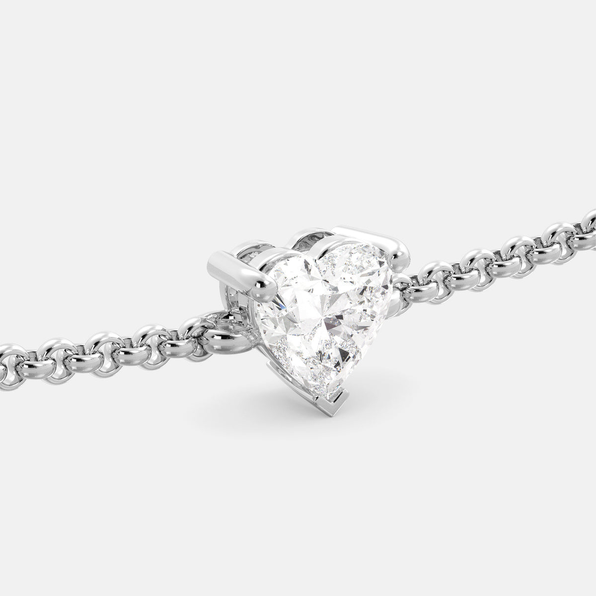 A close-up of a heart-shaped diamond bracelet in recycled white gold. The bracelet is set with a single, large diamond in the center of a heart-shaped pendant. The bracelet is made of recycled white gold and has a simple, elegant design. The diamond is sparkling and reflects light beautifully. The bracelet is a perfect gift for a loved one or a special occasion.