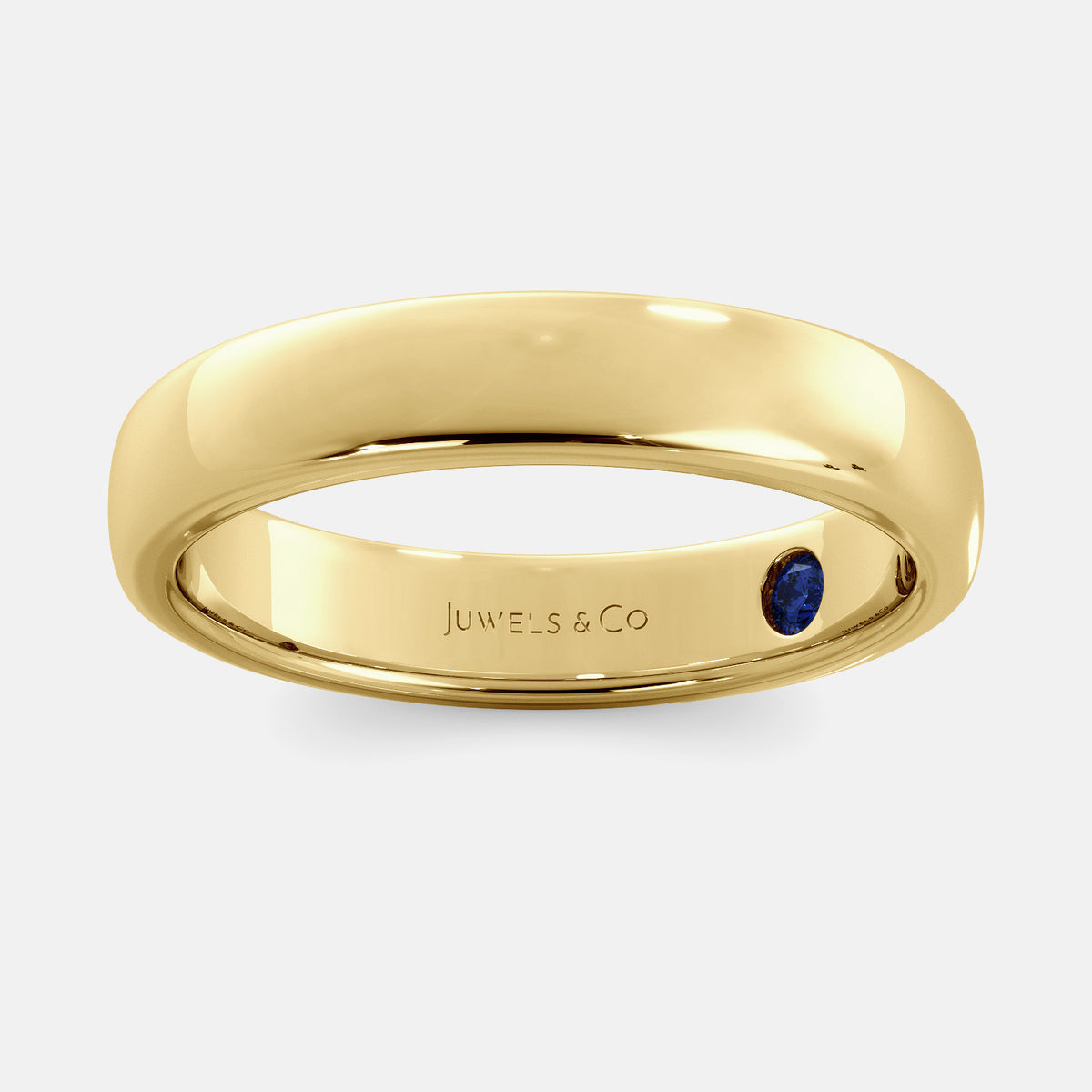 A close-up of a yellow gold flat wedding band with a hidden stone. The band is a classic and timeless design that is perfect for any occasion. The hidden stone can be customized with one of 12 different gemstones, including diamonds, rubies, sapphires, and emeralds. This makes the band a unique and personal choice for the wearer.