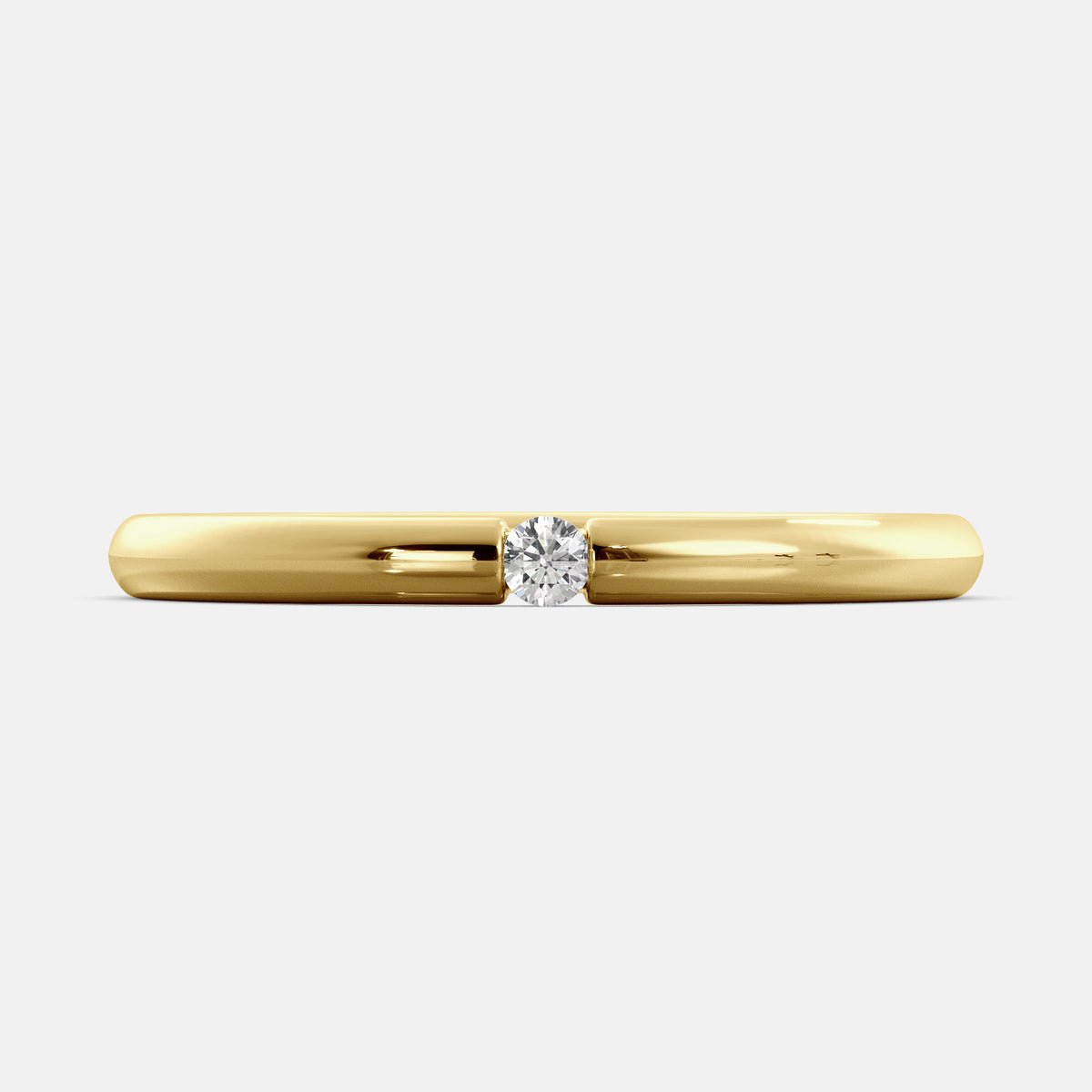 A close-up of a simple round wedding band in 14K yellow gold with a small round diamond in the center. The band is a classic and timeless design that is perfect for any occasion. The diamond is a beautiful accent that adds a touch of glamour.