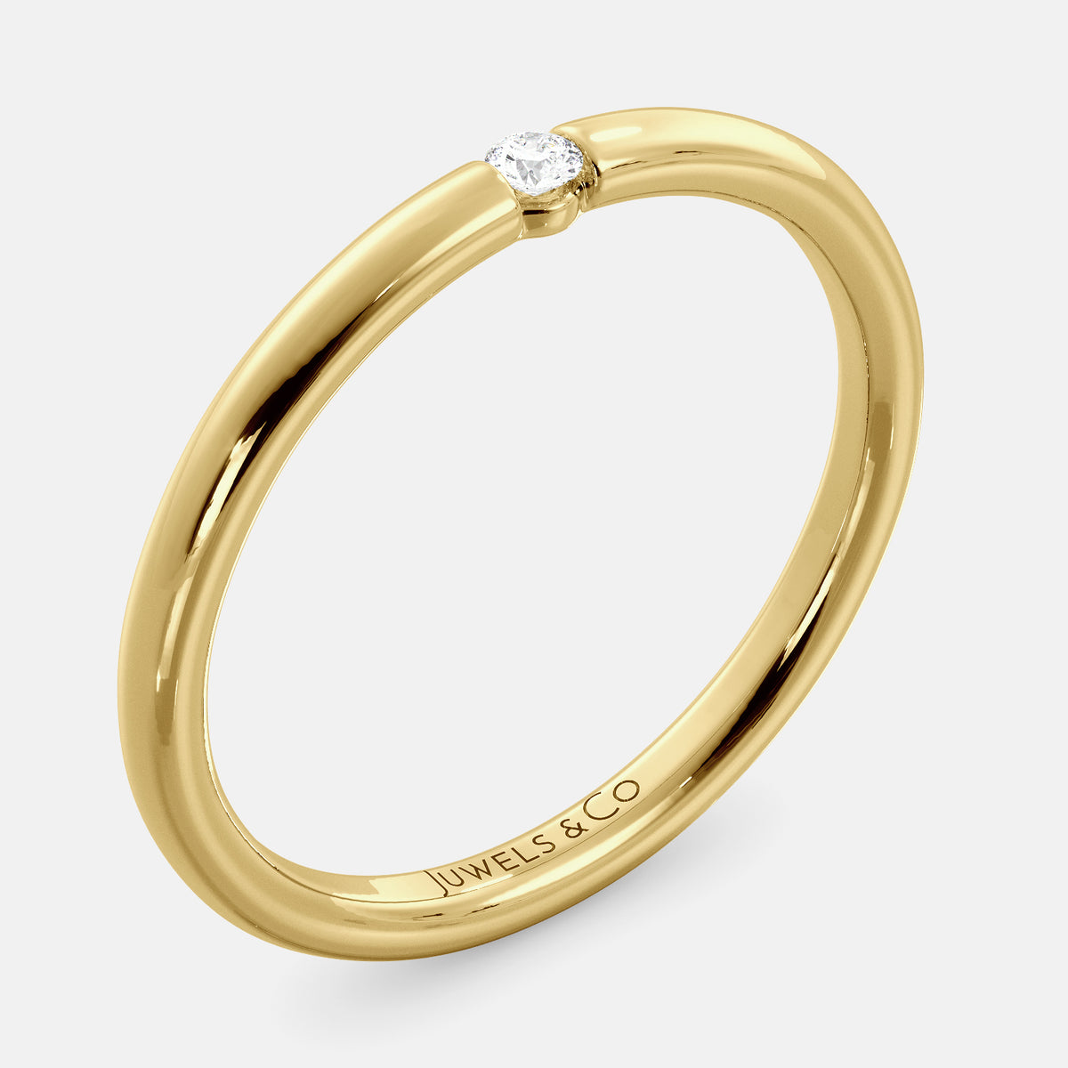 A close-up of a simple round wedding band in 14K yellow gold with a small round diamond in the center. The band is a classic and timeless design that is perfect for any occasion. The diamond is a beautiful accent that adds a touch of glamour.