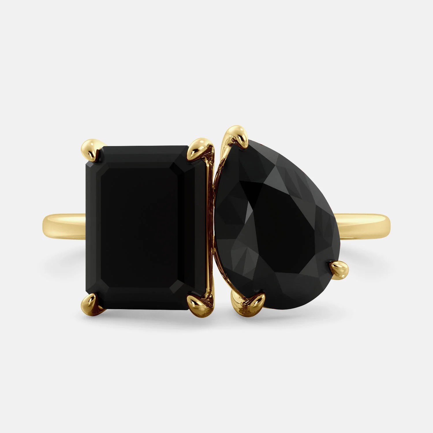 A toi et moi ring with a onyx stone in emerald cut and a pear-shaped stone. The onyx is a deep dark color and the pear-shaped stone can be customized to represent the birth month stone of the wearer or a loved one. The ring is made of 14k gold and is available in all sizes. This ring is a perfect gift for any occasion, and it can be customized to make it truly unique.