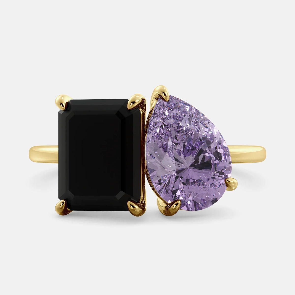 A toi et moi ring with a onyx stone in emerald cut and a pear-shaped stone. The onyx is a deep dark color and the pear-shaped stone can be customized to represent the birth month stone of the wearer or a loved one. The ring is made of 14k gold and is available in all sizes. This ring is a perfect gift for any occasion, and it can be customized to make it truly unique.