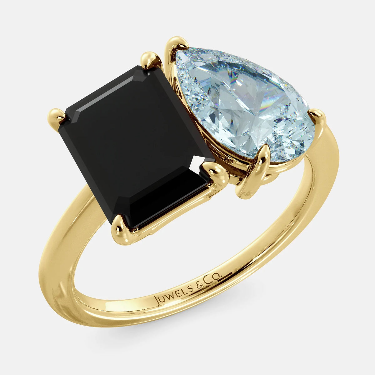 A toi et moi ring with a onyx stone in emerald cut and a pear-shaped stone. The onyx is a deep dark color and the pear-shaped stone can be customized to represent the birth month stone of the wearer or a loved one. The ring is made of 14k gold and is available in all sizes. This ring is a perfect gift for any occasion, and it can be customized to make it truly unique.