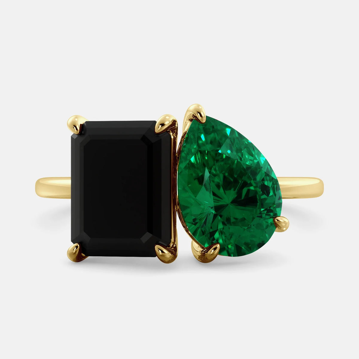 A toi et moi ring with a onyx stone in emerald cut and a pear-shaped stone. The onyx is a deep dark color and the pear-shaped stone can be customized to represent the birth month stone of the wearer or a loved one. The ring is made of 14k gold and is available in all sizes. This ring is a perfect gift for any occasion, and it can be customized to make it truly unique.