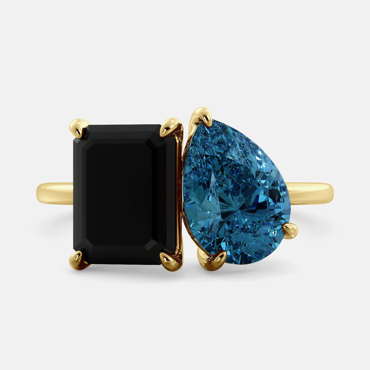 A toi et moi ring with a onyx stone in emerald cut and a pear-shaped stone. The onyx is a deep dark color and the pear-shaped stone can be customized to represent the birth month stone of the wearer or a loved one. The ring is made of 14k gold and is available in all sizes. This ring is a perfect gift for any occasion, and it can be customized to make it truly unique.