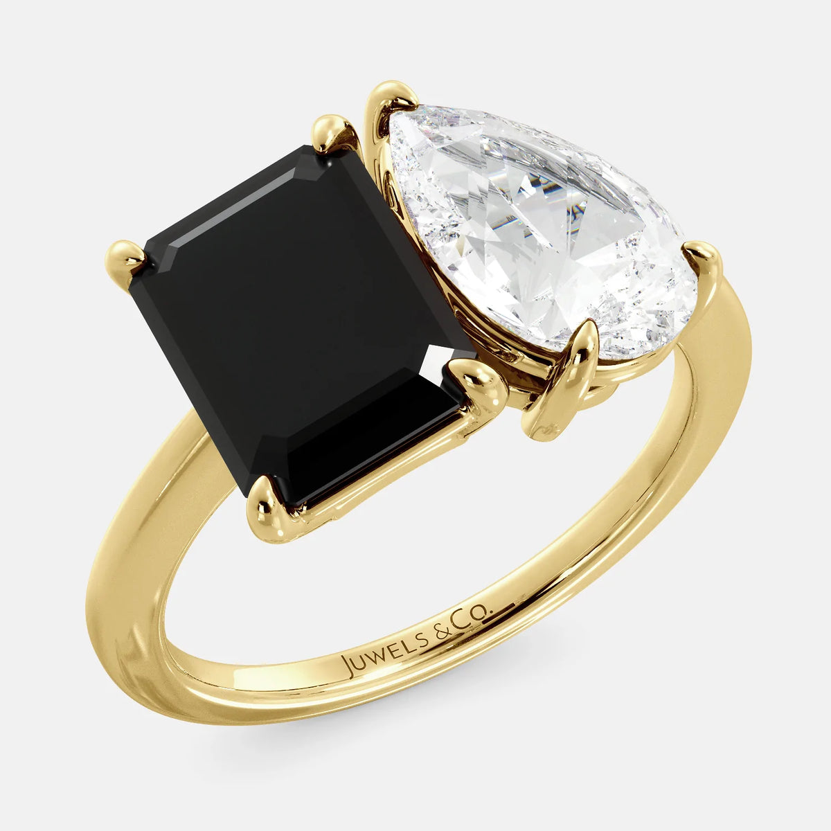 A toi et moi ring with a onyx stone in emerald cut and a pear-shaped stone. The onyx is a deep dark color and the pear-shaped stone can be customized to represent the birth month stone of the wearer or a loved one. The ring is made of 14k gold and is available in all sizes. This ring is a perfect gift for any occasion, and it can be customized to make it truly unique.