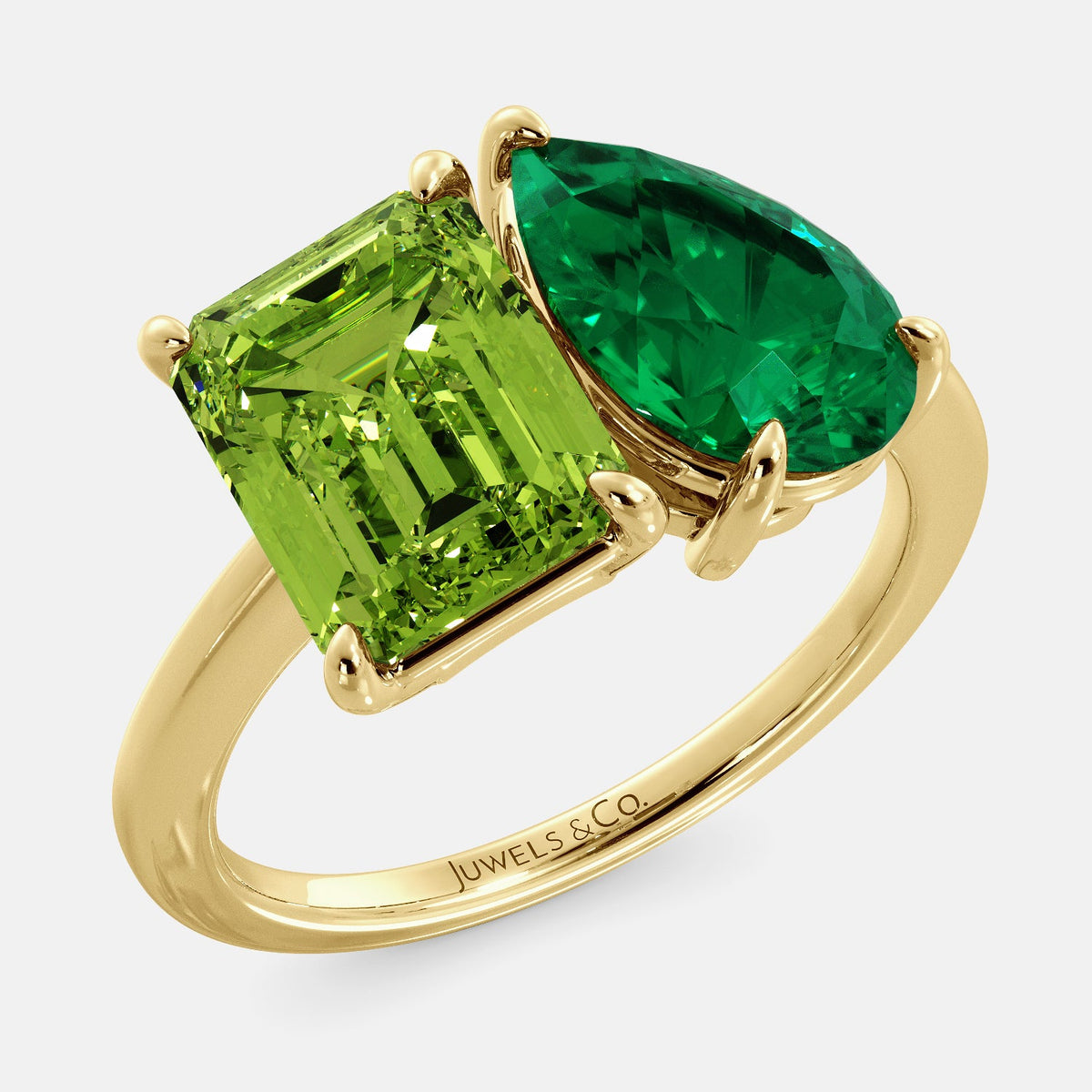 A toi et moi ring with an emerald-cut Green Peridot and a pear-cut gemstone. The emerald-cut morganite is set on the left of the ring, and the pear-cut gemstone is set on the right. The ring is made of recycled yellow gold and has a simple, elegant design. The pear-cut gemstone can be customized. **Here are some additional details about the image:** * The emerald-cut white Green Peridot is a birthstone for August. * The pear-cut gemstone can be customized to any stone of your choice.