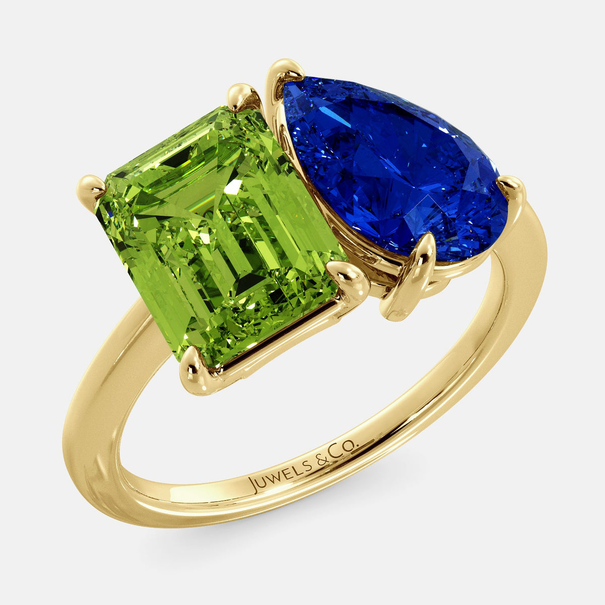 A toi et moi ring with an emerald-cut Green Peridot and a pear-cut gemstone. The emerald-cut morganite is set on the left of the ring, and the pear-cut gemstone is set on the right. The ring is made of recycled yellow gold and has a simple, elegant design. The pear-cut gemstone can be customized. **Here are some additional details about the image:** * The emerald-cut white Green Peridot is a birthstone for August. * The pear-cut gemstone can be customized to any stone of your choice.
