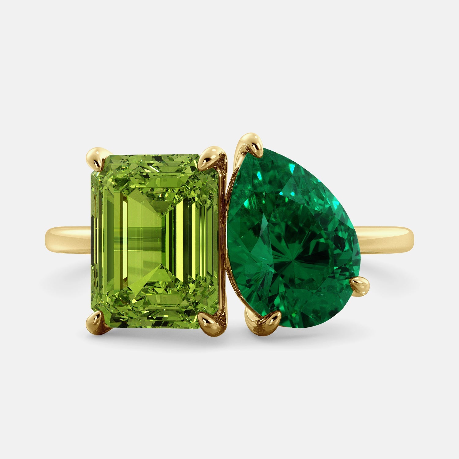 A toi et moi ring with an emerald-cut Green Peridot and a pear-cut gemstone. The emerald-cut morganite is set on the left of the ring, and the pear-cut gemstone is set on the right. The ring is made of recycled yellow gold and has a simple, elegant design. The pear-cut gemstone can be customized. **Here are some additional details about the image:** * The emerald-cut white Green Peridot is a birthstone for August. * The pear-cut gemstone can be customized to any stone of your choice.