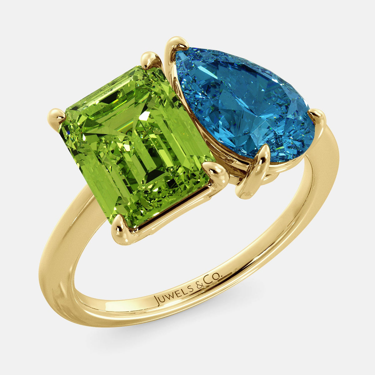 A toi et moi ring with an emerald-cut Green Peridot and a pear-cut gemstone. The emerald-cut morganite is set on the left of the ring, and the pear-cut gemstone is set on the right. The ring is made of recycled yellow gold and has a simple, elegant design. The pear-cut gemstone can be customized. **Here are some additional details about the image:** * The emerald-cut white Green Peridot is a birthstone for August. * The pear-cut gemstone can be customized to any stone of your choice.