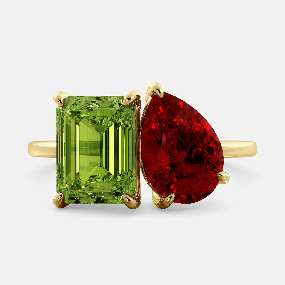 A toi et moi ring with an emerald-cut Green Peridot and a pear-cut gemstone. The emerald-cut morganite is set on the left of the ring, and the pear-cut gemstone is set on the right. The ring is made of recycled yellow gold and has a simple, elegant design. The pear-cut gemstone can be customized. **Here are some additional details about the image:** * The emerald-cut white Green Peridot is a birthstone for August. * The pear-cut gemstone can be customized to any stone of your choice.